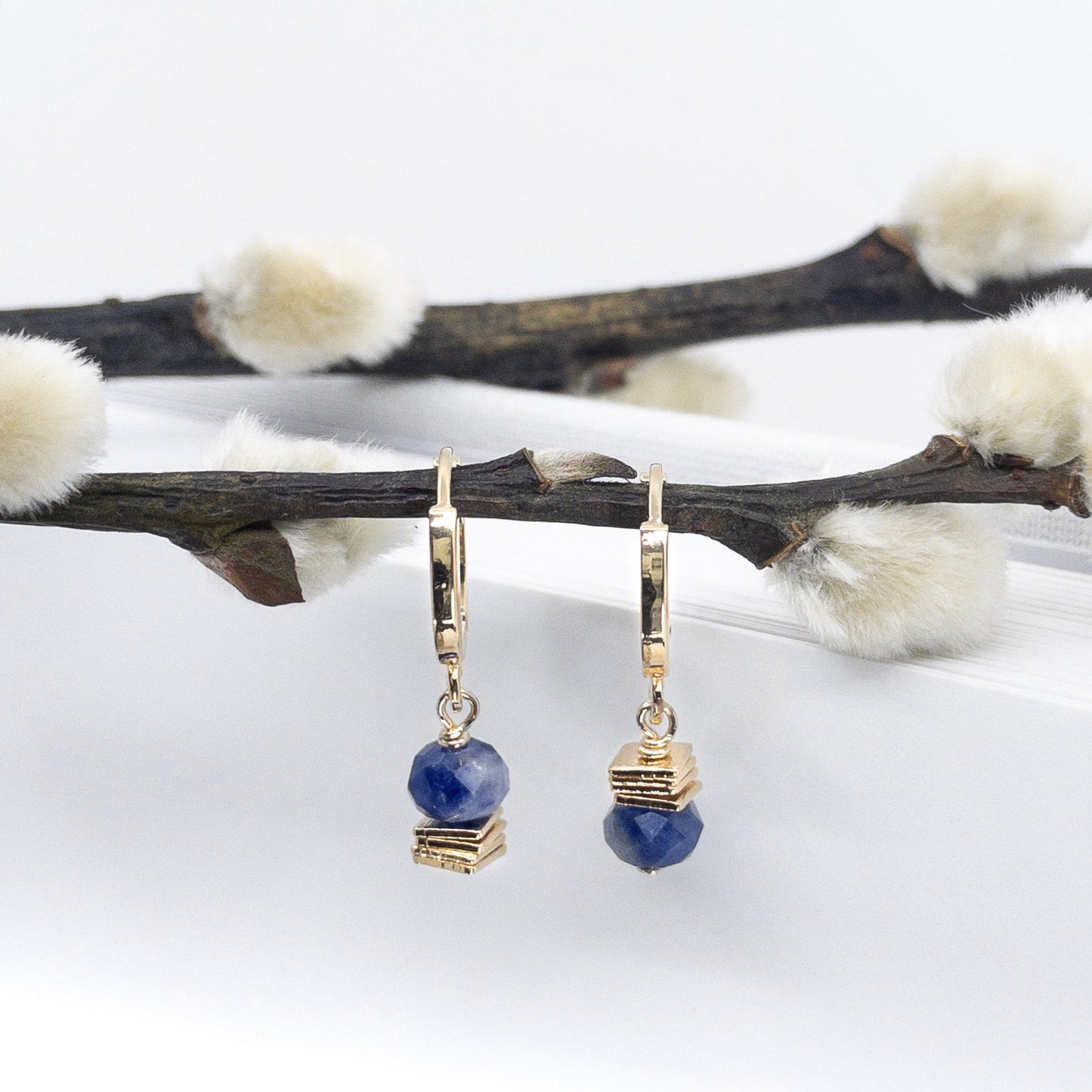 Boucles d'oreilles mini créoles avec pierres fines naturelles de Sodalite bleu profond. Quatre petits carrés plaqués or 18 carats sont empilés sous la perle pour l'un des anneau, au-dessus pour l'autre. Anneaux 1.2 cm de diamètre