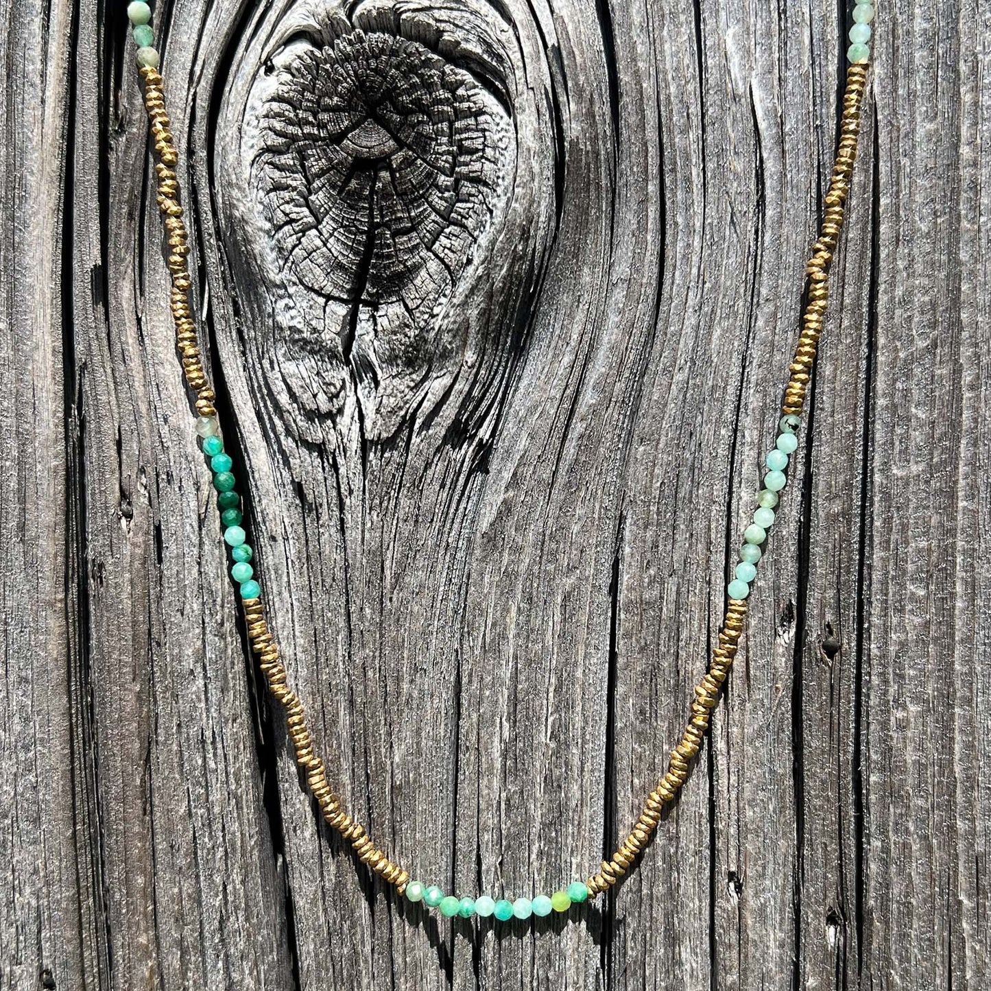 Collier en pierres fines naturelles d'amazonite aux différentes teintes de vert et hématite dorée. Longueur ajustable de 38-43 cm. Fermoir et chaîne d'extension en plaqué or.