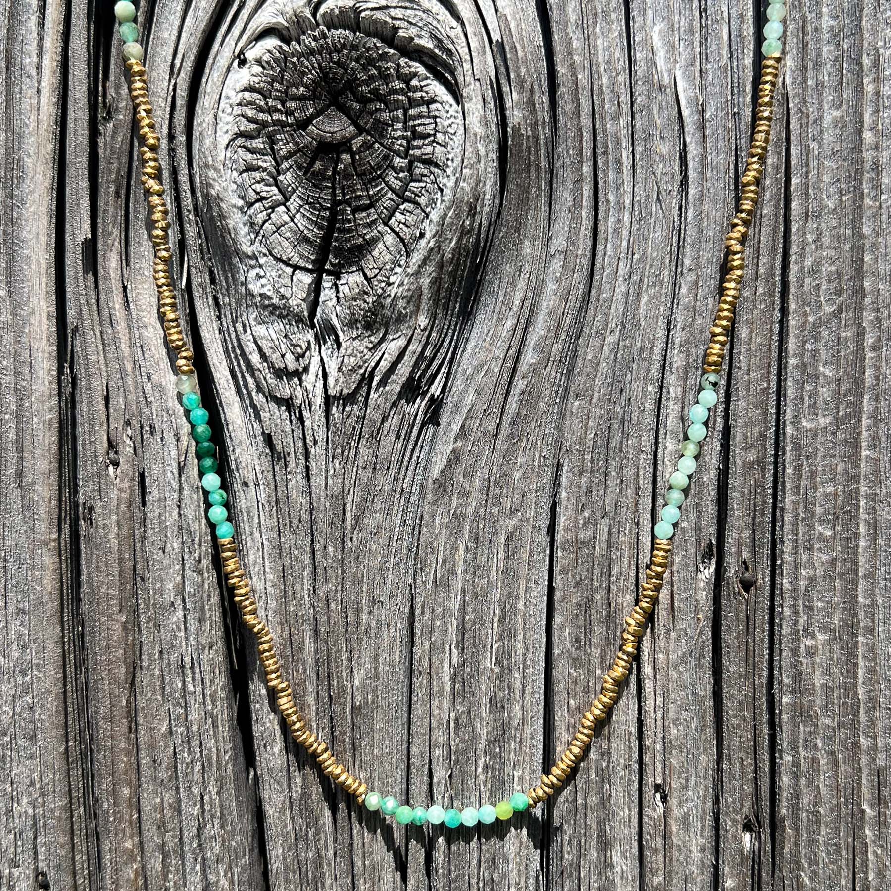 Collier en pierres fines naturelles d'amazonite aux différentes teintes de vert et hématite dorée. Longueur ajustable de 38-43 cm. Fermoir et chaîne d'extension en plaqué or.