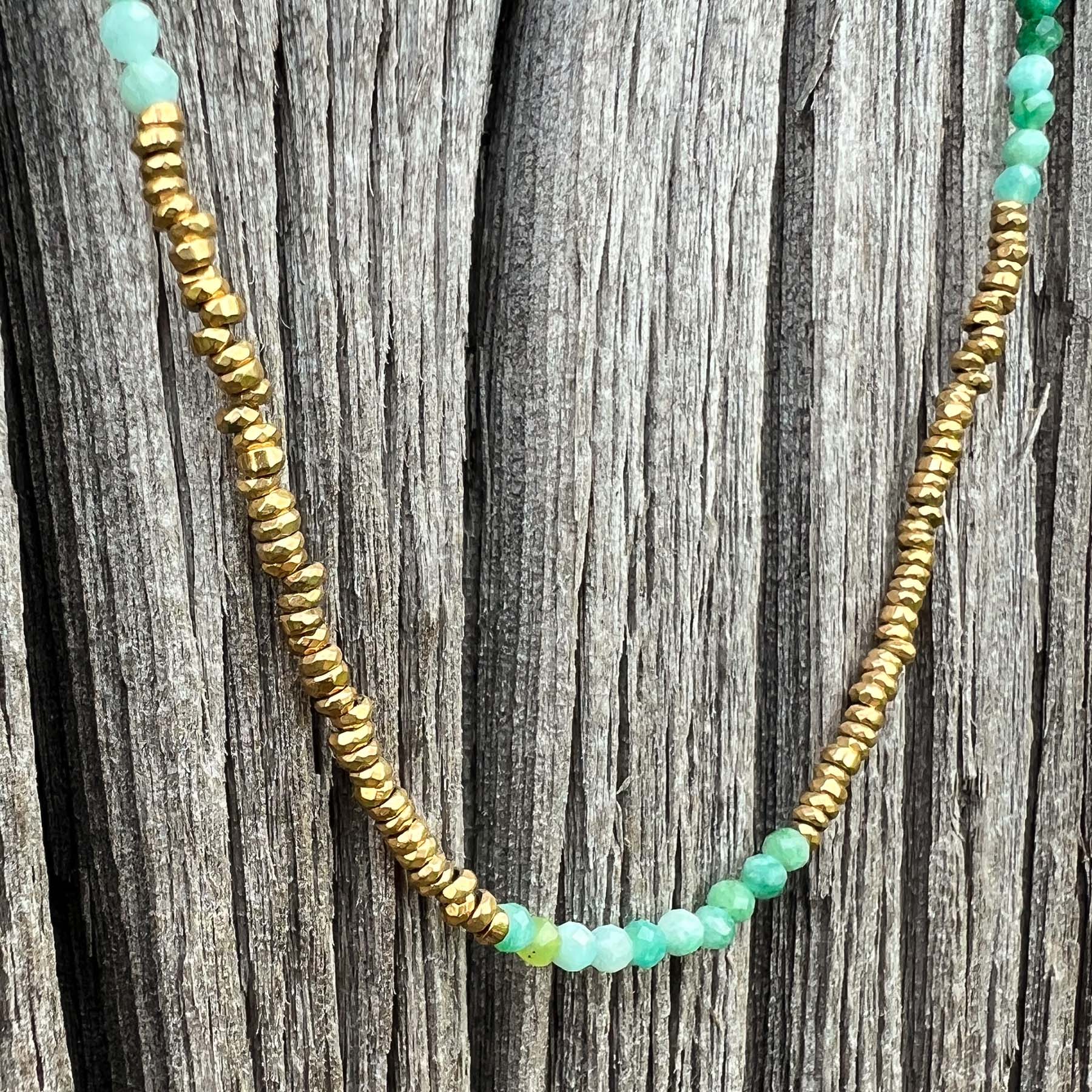 Collier en pierres fines naturelles d'amazonite aux différentes teintes de vert et hématite dorée. Longueur ajustable de 38-43 cm. Fermoir et chaîne d'extension en plaqué or.