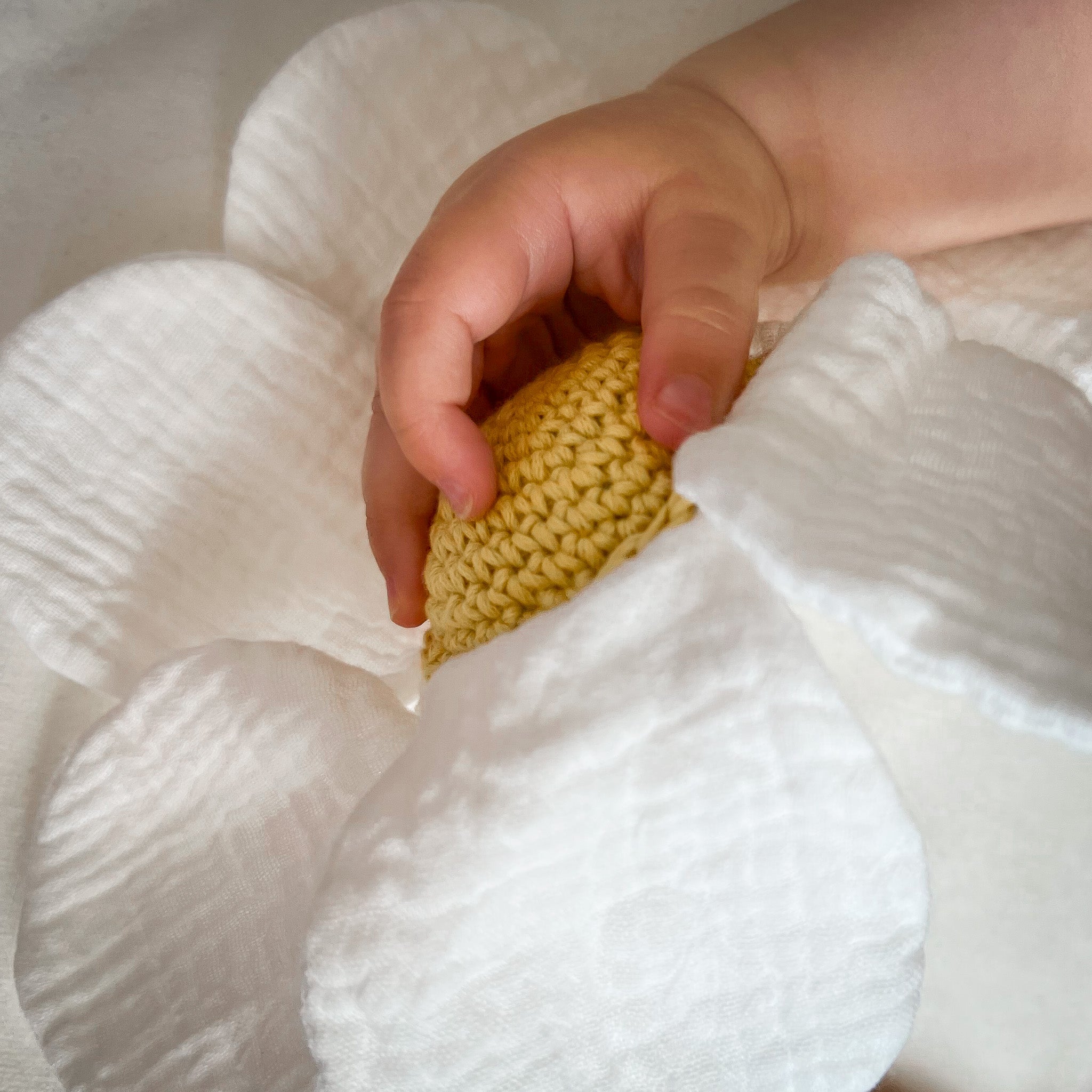 Doudou pour bébé fleur de camomille blanche et cœur jaune, en coton biologique certifié GOTS et crochet fait à la main.